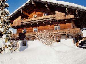 a log cabin with a pile of snow in front of it at Pleasant apartment in Bavaria in Neureichenau