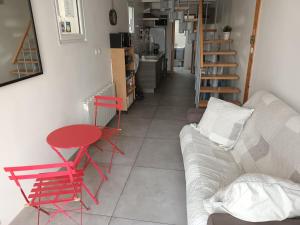 - un salon avec une table rouge et un canapé dans l'établissement Adopt'île, au Château-dʼOléron