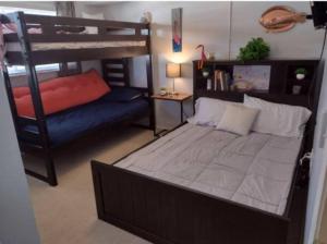een slaapkamer met een stapelbed en een bank bij Pelican Inlet-Cozy Beach Condo! in St. Augustine