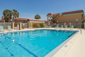 a large swimming pool at a hotel with chairs at Pelican Inlet-Cozy Beach Condo! in St. Augustine