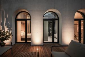 a room with three arched windows and a bedroom at Mynt Merano Rooms in Merano