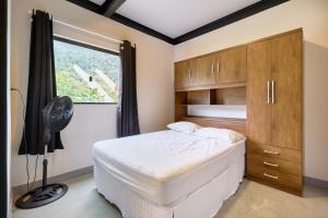 a bedroom with a bed and a window at Moderna do Prumirim in Ubatuba