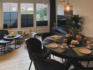 une salle à manger avec une table et des chaises et une cuisine dans l'établissement Raceweide - MarBi Alles inbegrepen, à Dangast