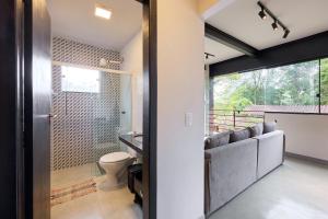 a bathroom with a toilet and a glass door at Moderna do Prumirim in Ubatuba +60 photos