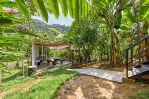 an outdoor patio with a picnic table in a forest at Moderna do Prumirim in Ubatuba