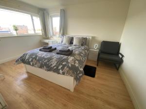 a bedroom with a bed and a chair in it at Spacious three bedroom property in Penrhyn bay - sleeps 6 in Penrhyn Bay