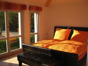 een slaapkamer met een bed met een lederen hoofdeinde en ramen bij Luxury holiday home with sauna in Heiligendamm
