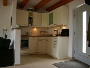 una cocina con armarios blancos y una ventana en Luxury holiday home with sauna en Heiligendamm