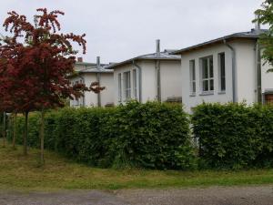 una casa blanca con arbustos delante en Luxury holiday home with sauna en Heiligendamm