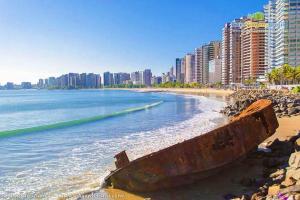 un viejo barco sentado en la orilla de una playa en HOTEL CENTRAL DE FORTALEZA, en Fortaleza