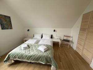 a white bedroom with a bed and a desk at Agroturystyka Kraina Choszcza in Choszczno