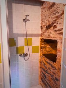 a bathroom with a shower with a stone fireplace at Casa do Salgueirinho in Casal do Rei