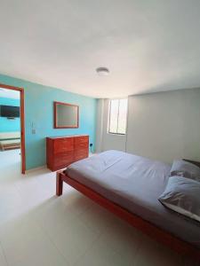 a bedroom with a bed and a dresser in it at Apartamento 10c Edf.Playa in Santa Marta