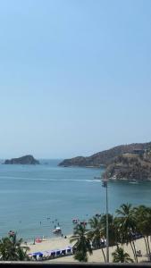 a beach with palm trees and people in the water at Apartamento 10c Edf.Playa in Santa Marta