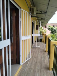 un pasillo vacío de un edificio escolar con paredes amarillas en Moradia Turistica MJ ROOMS CITY, en São Tomé
