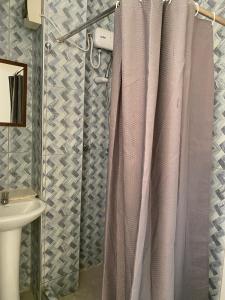 a bathroom with a shower curtain and a sink at Hotel House Hoskins Talara- con AIRE ACONDICIONADO, uso de cocina in Talara