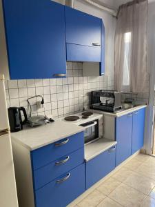 a kitchen with blue cabinets and a stove at Dimos apartments in Kókkinon Nerón