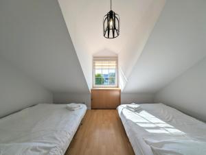 2 łóżka w sypialni na poddaszu z oknem w obiekcie Sunflower Park Apartment w mieście Międzyzdroje