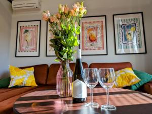 stół z dwoma kieliszkami do wina i wazon z kwiatami w obiekcie Sunflower Park Apartment w mieście Międzyzdroje