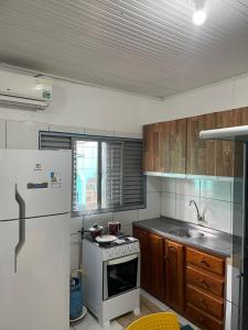 La cuisine est équipée d'une cuisinière blanche et d'un réfrigérateur. dans l'établissement POUSADA TORRE FORTE ac, à Rio Branco