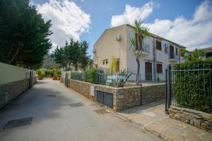 a house with a fence next to a street at SanVitoTour- Residence Il Baglio in San Vito lo Capo