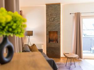 a living room with a couch and a fireplace at AlpenLuxus' ALTE MÜHLE LOFT with balcony & car park in Brixlegg