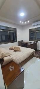 1 dormitorio con 1 cama grande y 1 mesa en استديوهات الجبل, en Jerash