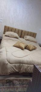 Una cama con dos almohadas encima. en استديوهات الجبل, en Jerash