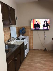 eine Küche mit einem an der Wand hängenden TV in der Unterkunft Apartman Spasic in Ribarska Banja