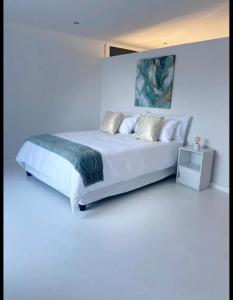 a white bedroom with a large white bed with pillows at DMK GUESTHOUSE 2 in Cape Town