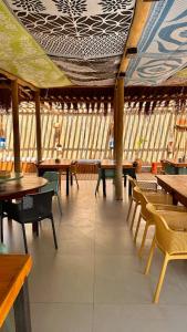 a dining room with tables and chairs and windows at Pousada Alto Mar in Fernando de Noronha