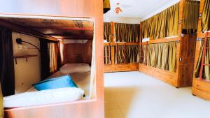2 camas en una habitación con paredes de madera en HOT - House Of Travellers en Rishīkesh