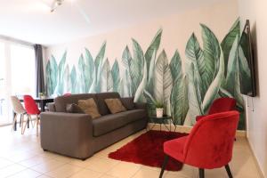 a living room with a couch and red chairs at Plaza Vienne 01 in Montévrain