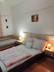 a bedroom with a bed and two night stands at Abádi Karmazsin Ház in Abádszalók