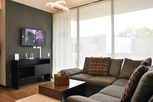 uma sala de estar com um sofá e uma televisão de ecrã plano em Infinity Pool Apartment em San Salvador