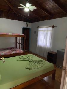 Corcovado Hostel في بويرتو خيمينيز: غرفة نوم بسريرين بطابقين ومروحة سقف