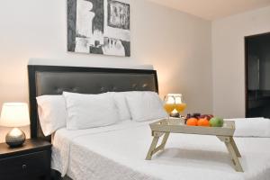 a bedroom with a bed with a tray of fruit on it at Infinity Pool Apartment in San Salvador