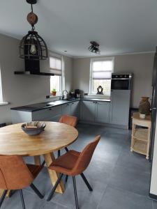 a kitchen with a wooden table and chairs in it at NIEUW Vakantiewoning Nimmerdor, Grijpskerke, dichtbij strand en stad in Grijpskerke