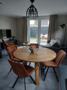 a living room with a wooden table and chairs at NIEUW Vakantiewoning Nimmerdor, Grijpskerke, dichtbij strand en stad in Grijpskerke