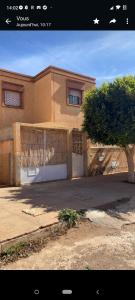 una casa con un garaje y un árbol delante de él en Maison avec terrasse et spa, en Oujda