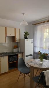 a kitchen with a table and a white refrigerator at Apartament 35 in Zamość