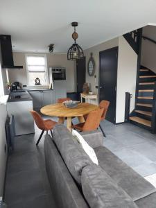 a living room with a couch and a table at NIEUW Vakantiewoning Nimmerdor, Grijpskerke, dichtbij strand en stad in Grijpskerke