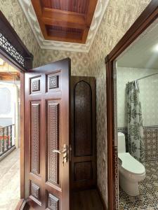 baño con aseo y puerta en Vaziri A'zam Hotel, en Bukhara
