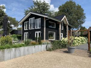 ein schwarzes Haus mit Garten davor in der Unterkunft B&B Gebakhuus in Kring van Dorth