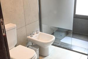 biała łazienka z toaletą i umywalką w obiekcie Moller Masi - Ayllu Huasi w mieście Purmamarca