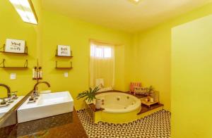 uma casa de banho amarela com uma banheira e um lavatório em Rizzu Marina Hotel em Balneário Camboriú