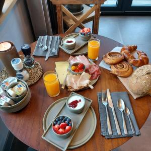 una mesa cubierta con platos de desayuno y zumo de naranja en B&B Gebakhuus, en Kring van Dorth