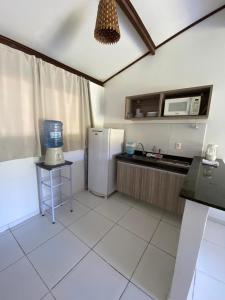een keuken met een koelkast en een magnetron bij House Anthony and Cleusa 36 Quinta do Rio in Pipa