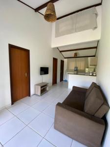 een woonkamer met een bank en een televisie bij House Anthony and Cleusa 36 Quinta do Rio in Pipa