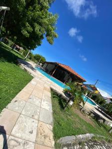 een huis met een palmboom naast een stoep bij House Anthony and Cleusa 36 Quinta do Rio in Pipa
